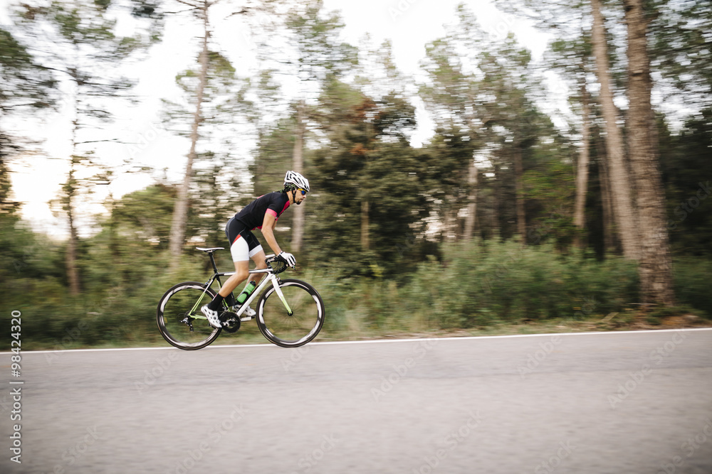 Cyclist riding a bike on a road Cyclist riding a bike on a road