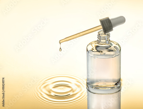 Moisturizing serum for dry skin, yellow background, pipette with drop, splash.