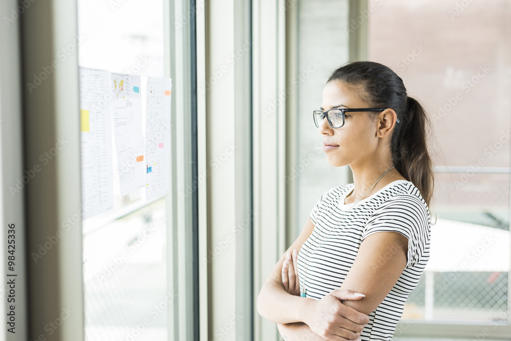 Young woman looking at papers at the window Young woman looking at papers at the window