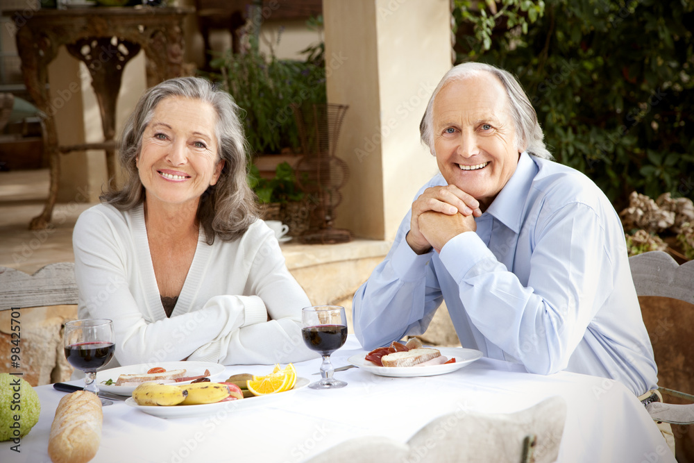 Spain, Mallorca, happy couple sitting at laid table in the garden Spain, Mallorca, happy couple sitting at laid table in the garden