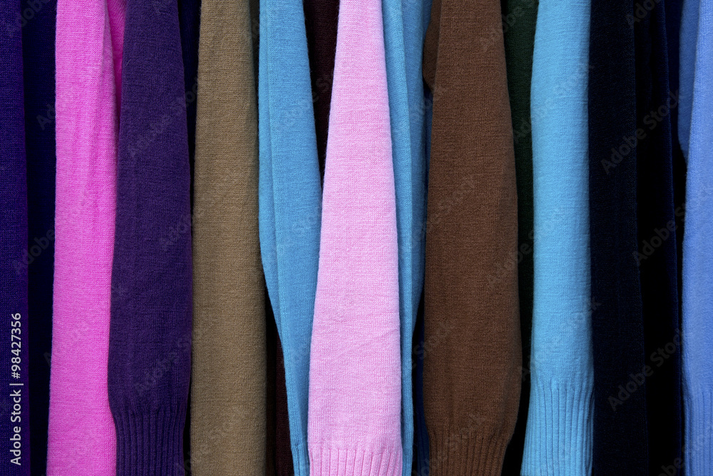 Colors of rainbow. Variety of casual clothes on wooden hangers, isolated