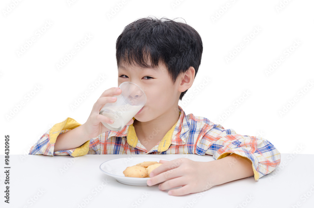 Asian boy eating cookies with milk over white Asian boy eating cookies with milk over white
