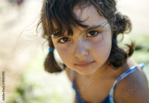 Portrait of serious looking little girl on the beach photo