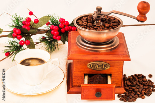 Retro coffee mill and cup of coffee on white backgrownd