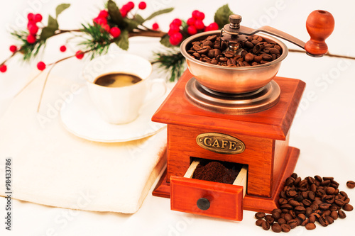 Retro coffee mill and cup of coffee on white backgrownd