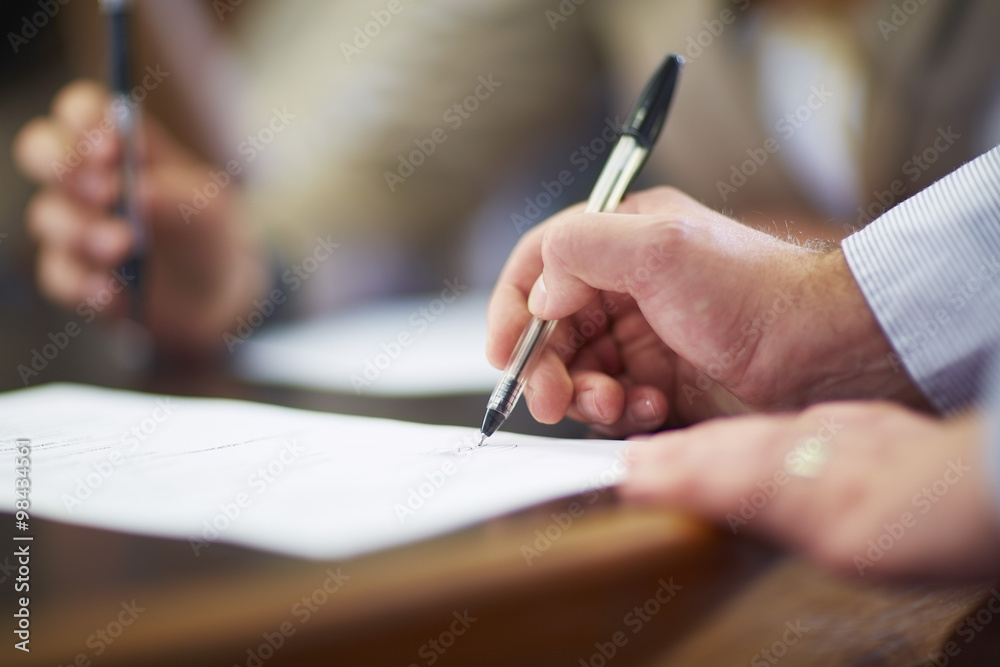 Businessman signing document in boardroom Businessman signing document in boardroom