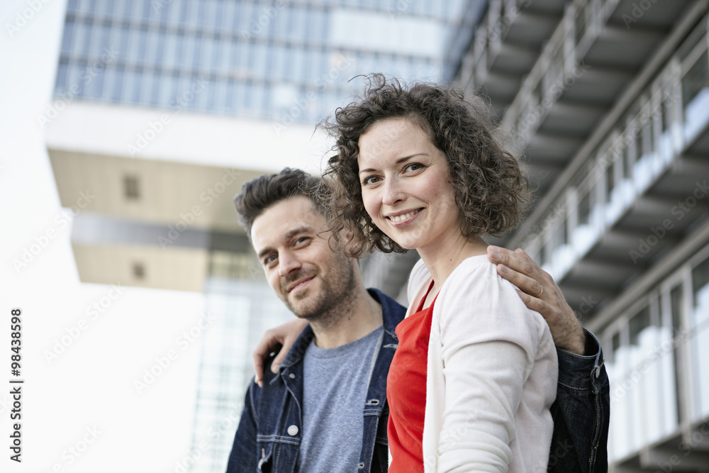 Germany, North Rhine-Westphalia, Cologne, portrait of couple in front of facade at Rheinauhafen Germany, North Rhine-Westphalia, Cologne, portrait of couple in front of facade at Rheinauhafen