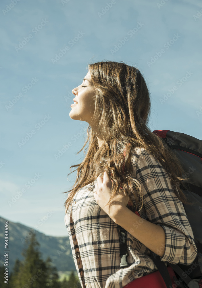 Austria, Tyrol, Tannheimer Tal, young woman on hiking trip enjoying sunshine Austria, Tyrol, Tannheimer Tal, young woman on hiking trip enjoying sunshine