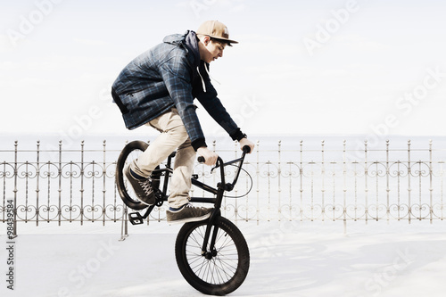 Germany, Schleswig Holstein, Teenage boy jumping with BMX bike