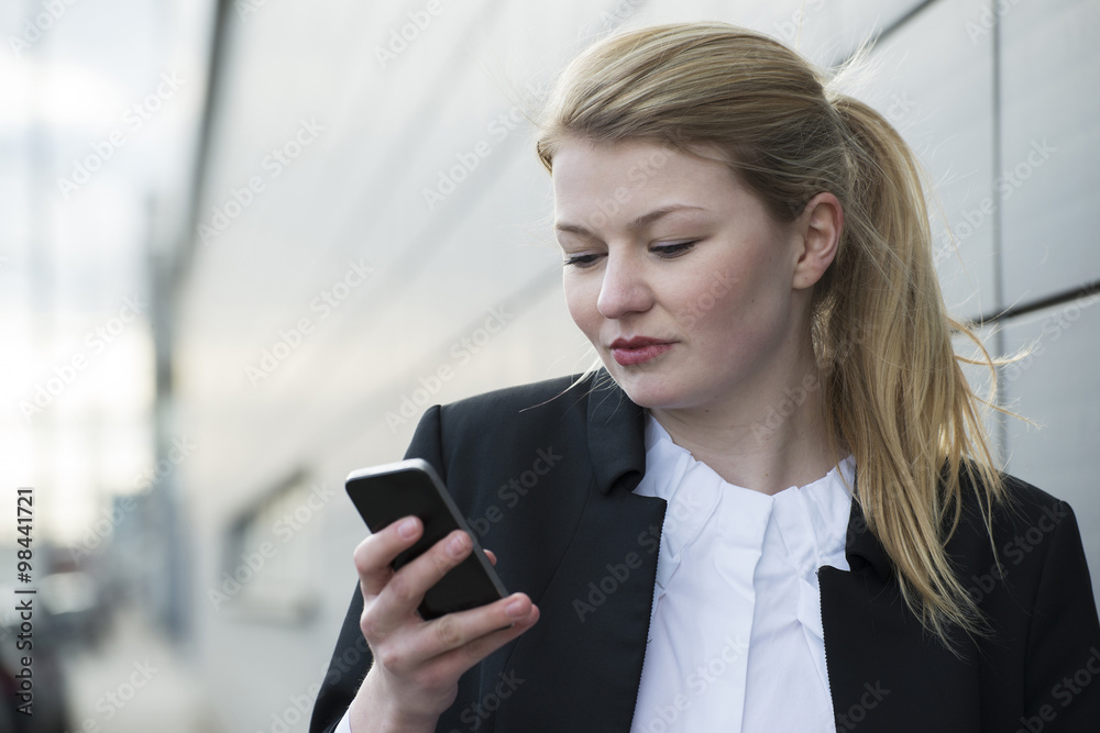 Germany, Mannheim, Young businesswoman using mobile phone Germany, Mannheim, Young businesswoman using mobile phone