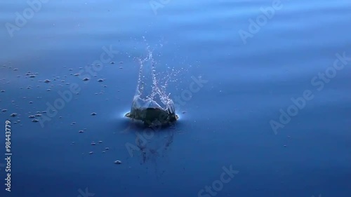 Slow motion of boulder thrown into the calm blue water. Great moving background with meditative effect. Relaxing view of the calm water. Full HD footage 1920x1080.
