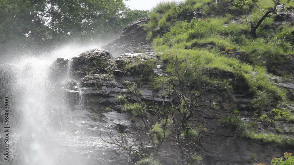 Beautiful cascading Hivrem waterfall producing mist in the rain forest in Goa, India during the monsoon rainy season Beautiful cascading Hivrem waterfall producing mist in the rain forest in Goa, India during the monsoon rainy season