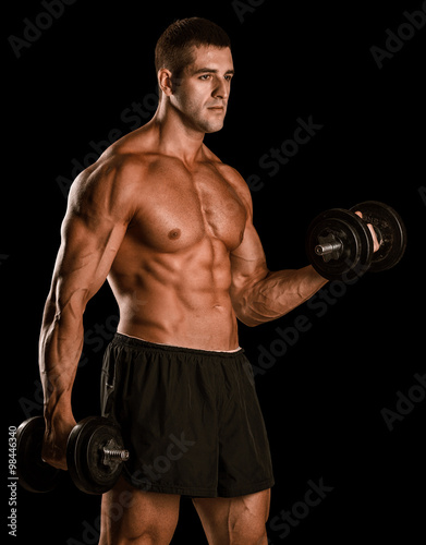 Closeup of a muscular young man lifting weights © romanolebedev