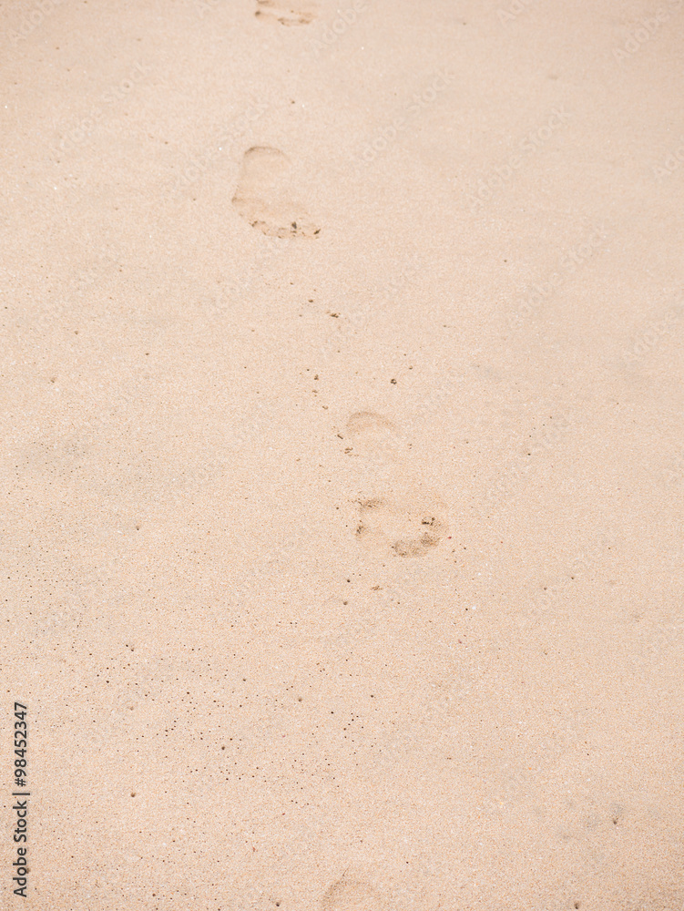 Close up of footprints on the beach sand at the sunset Close up of footprints on the beach sand at the sunset