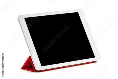 Tableta sobre fondo blanco situada en soporte rojo photo