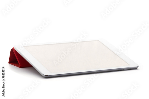 Tableta sobre fondo blanco tumbada en soporte rojo photo