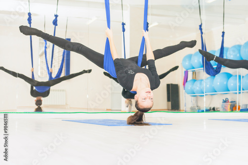 Teenager girl doing stretching and twine, aerial yoga