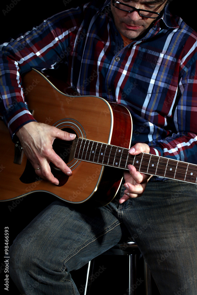 Obraz premium Mann spielt Gitarre,schwarzer Hintergrund
