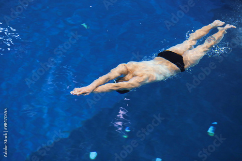 Male swimmer at the swimming pool. Underwater photo.