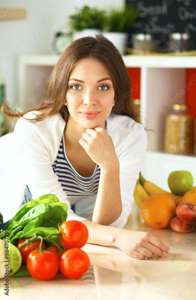 Young woman sitting near desk in the kitchen Young woman sitting near desk in the kitchen