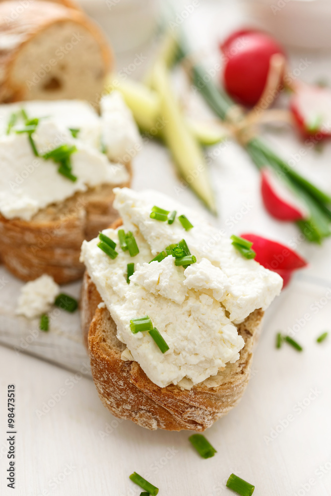 Canapes with curd cheese and fresh chive on a white table. Delicious and healthy breakfast