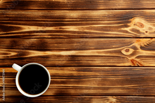 Cup of coffee on a brown wooden table
