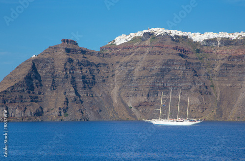 Santorini - The yacht and the cliffs under Imerovigli and Scaros castle. photo
