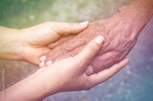 Senior and young holding hands with vintage color tone