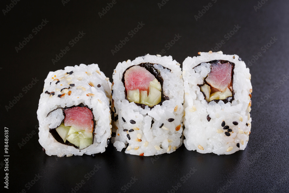 fresh sushi roll with tuna and cucumber, on black backgorund fresh sushi roll with tuna and cucumber, on black backgorund