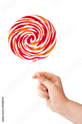 Color lollipop in child hand isolated on white