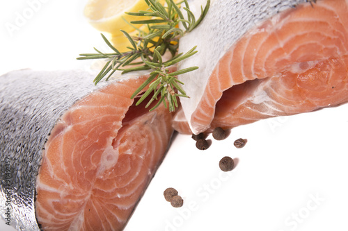 Two piece of fresh salmon with lemon and rosemary on a white background