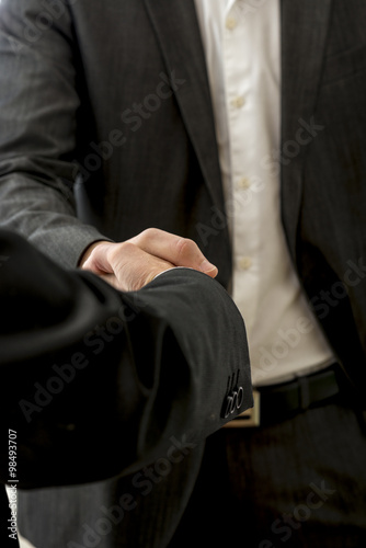Closeup of two male business partners shaking hands