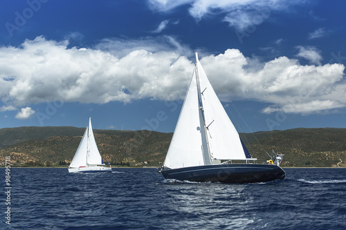 Fototapeta Naklejka Na Ścianę i Meble -  Sailing ship yachts with white sails in a row on the sea.