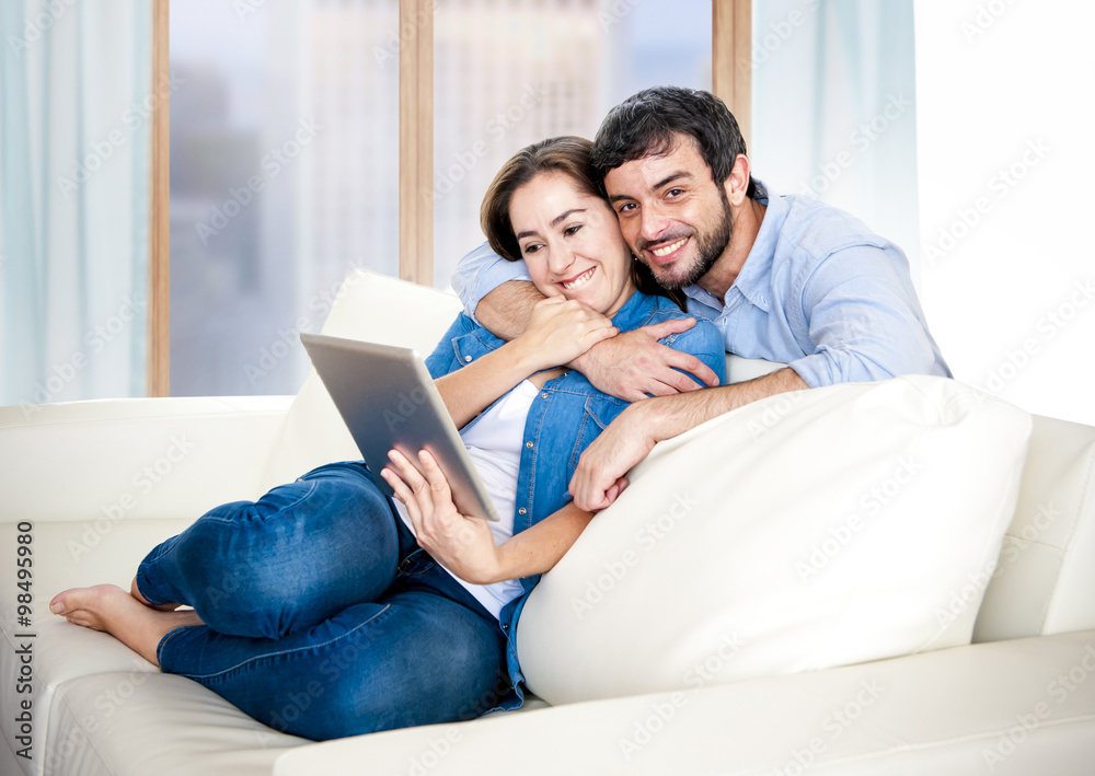 beautiful latin couple in love lying together on living room sofa couch enjoying using digital tablet beautiful latin couple in love lying together on living room sofa couch enjoying using digital tablet