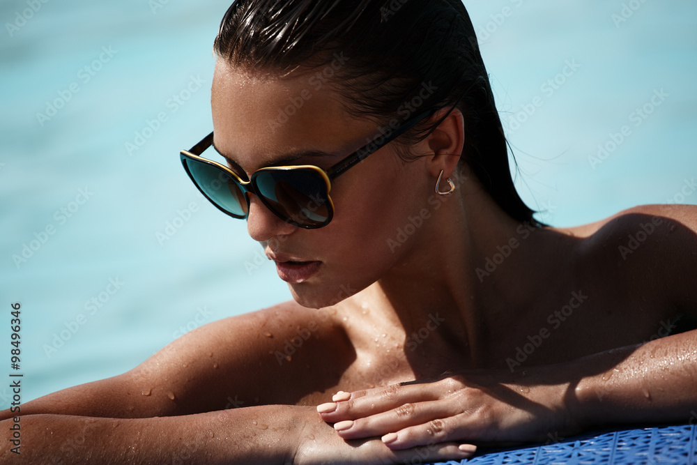 Portrait of a beautiful sexy girl with sunglasses in the swimming pool - obrazy, fototapety, plakaty 