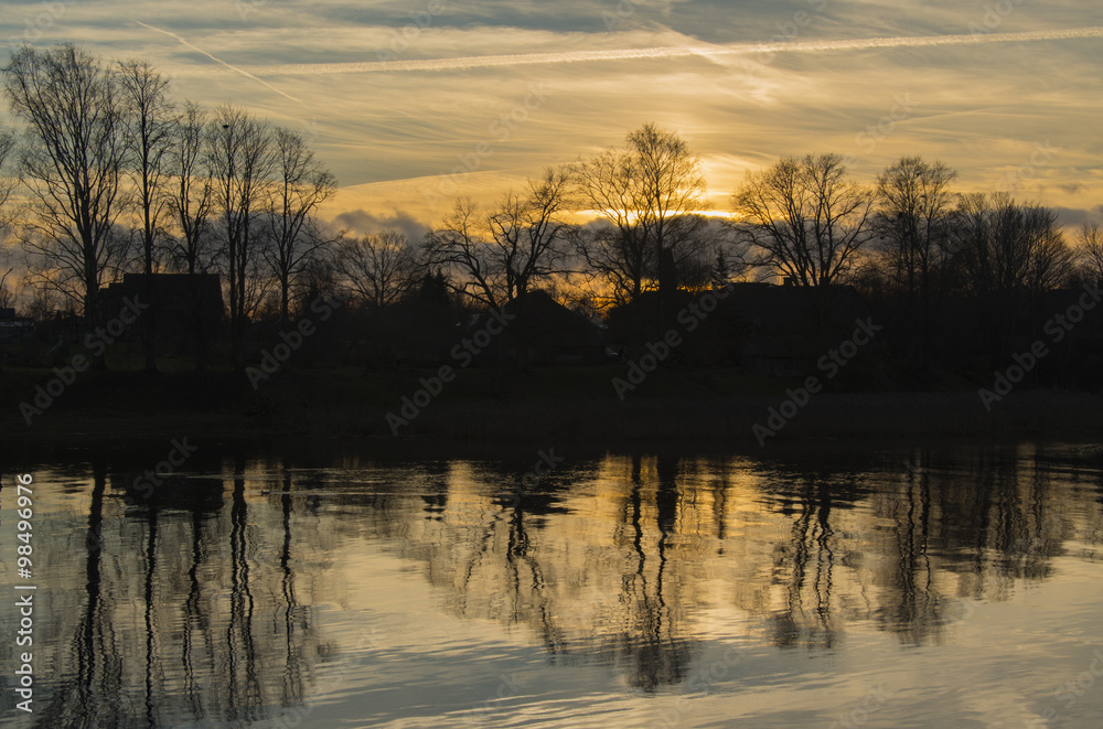 Obraz premium sunset at river with trees reflection on water
