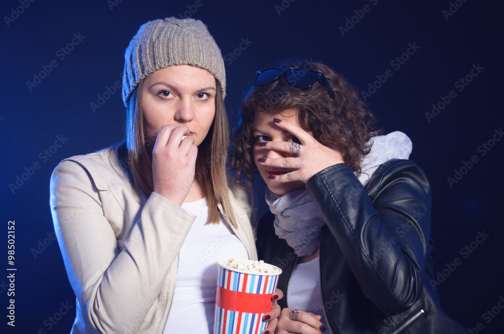 Two girls are watching horror movie in cinema Two girls are watching horror movie in cinema