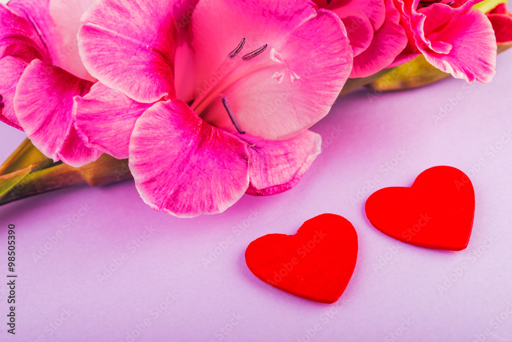 Obraz premium gladiolus and heart on a wooden background. Love concept background