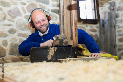 Woodworker on lathe in workroom