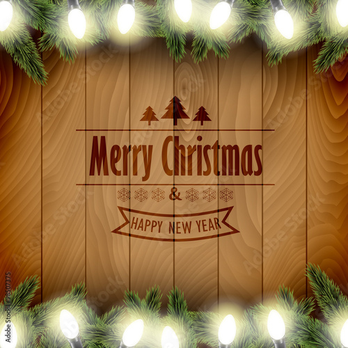 Christmas card with pine tree branches and Christmas lights on a wooden board.