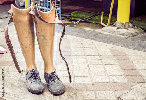 Old prosthetic legs set on a cement floor. Outdoor view