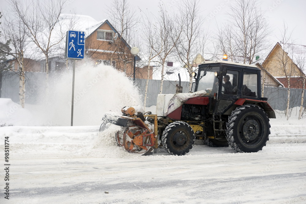 Tractor with plow, rotary mechanism clears the street of snow