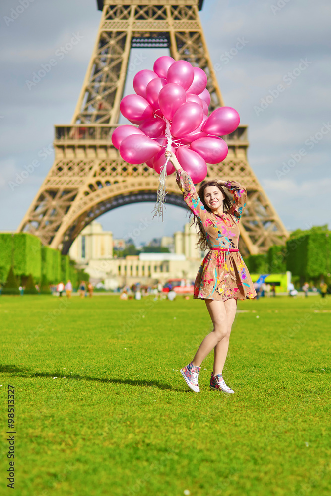 Happy young girl with huge bunch of pink balloons