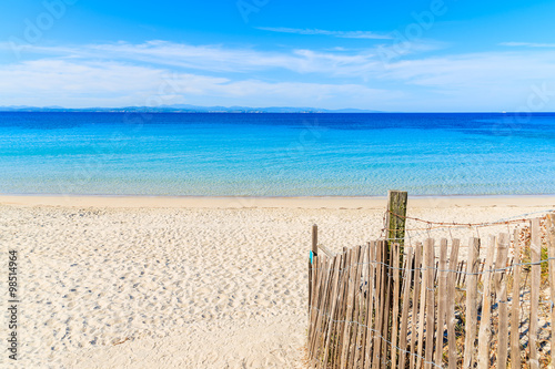 Wooden fence leading to beautiful white sand beach Grande Sperone with azure sea water  Corsica island  France