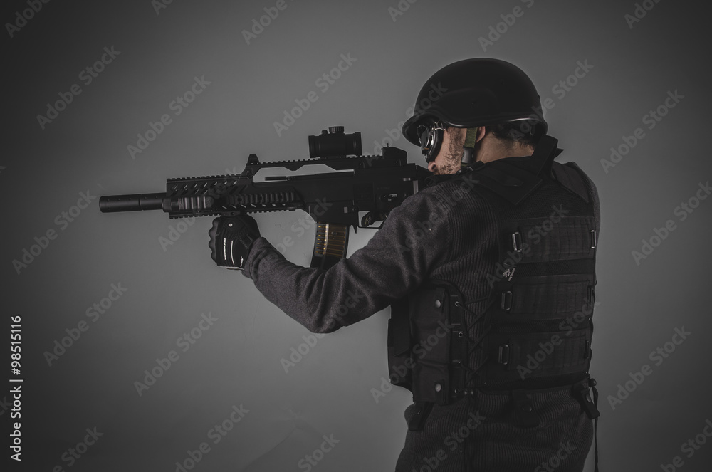 shooting, airsoft player with gun, helmet and bulletproof vest o