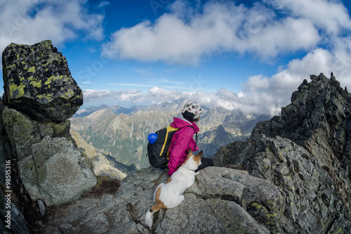 female hiker and her dog on a rocky mountain top