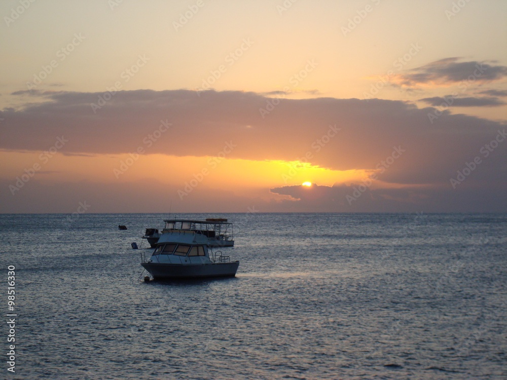 Boats on water at sunset, Dominica, Caribbean Boats on water at sunset, Dominica, Caribbean
