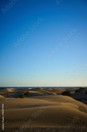 Brown Dunes of large beach under blue sky    Large sandy dunes in a wide desert next to southbeach of Gran Canaria