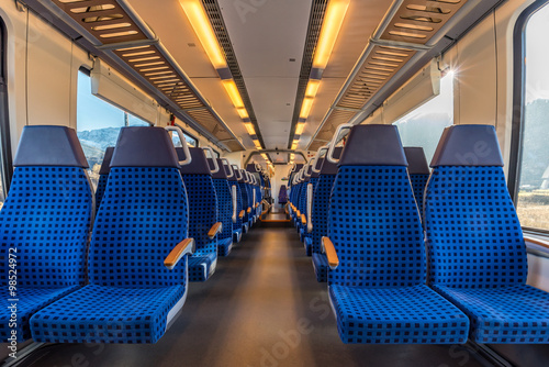 Image with the interior of a german border train. A modern train with comfortable and colorful chairs.