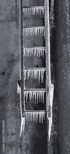 Pointy icicles hang down from rusty iron ladder